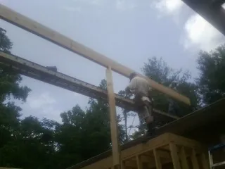 Carpenter setting a ridge beam over a new addition frame — Ice Dam Removal by Roofing Brothers in East Freetown