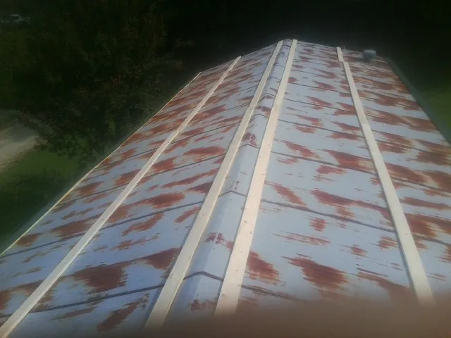 Rusted metal roof panels with new wood purlins before replacement — Storm Damage Roof Repair in East Freetown by Roofing Brothers